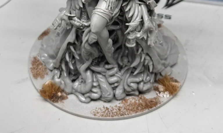 Kingdom Death Parasite Queen custom scenic base work in progress, front view showing tentacles, texture, and grass tufts on round base