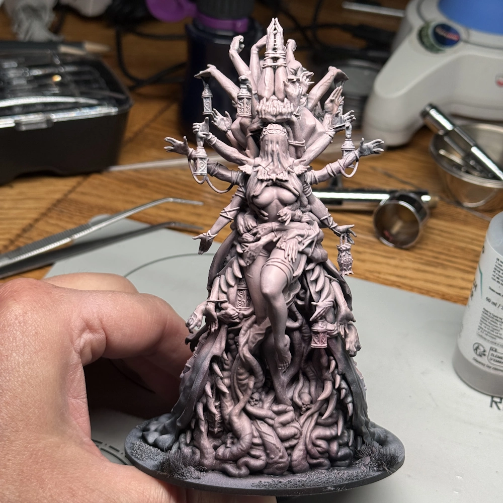 Kingdom Death Parasite Queen work in progress with initial pink skin basecoat, showing multiple arms, tentacles, lanterns, and custom scenic base